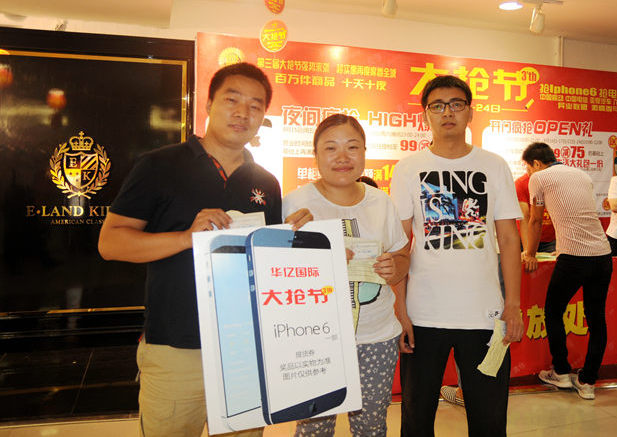 三位搶到iPhone6手機(jī)的顧客開心合影
